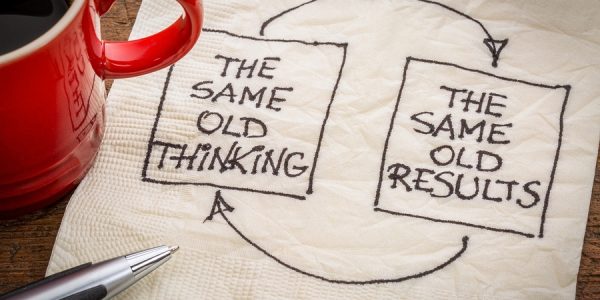 Two boxes drawn on a napkin pointing at each other with arrows. One says "The same old thinking" the other box says "The same old results"